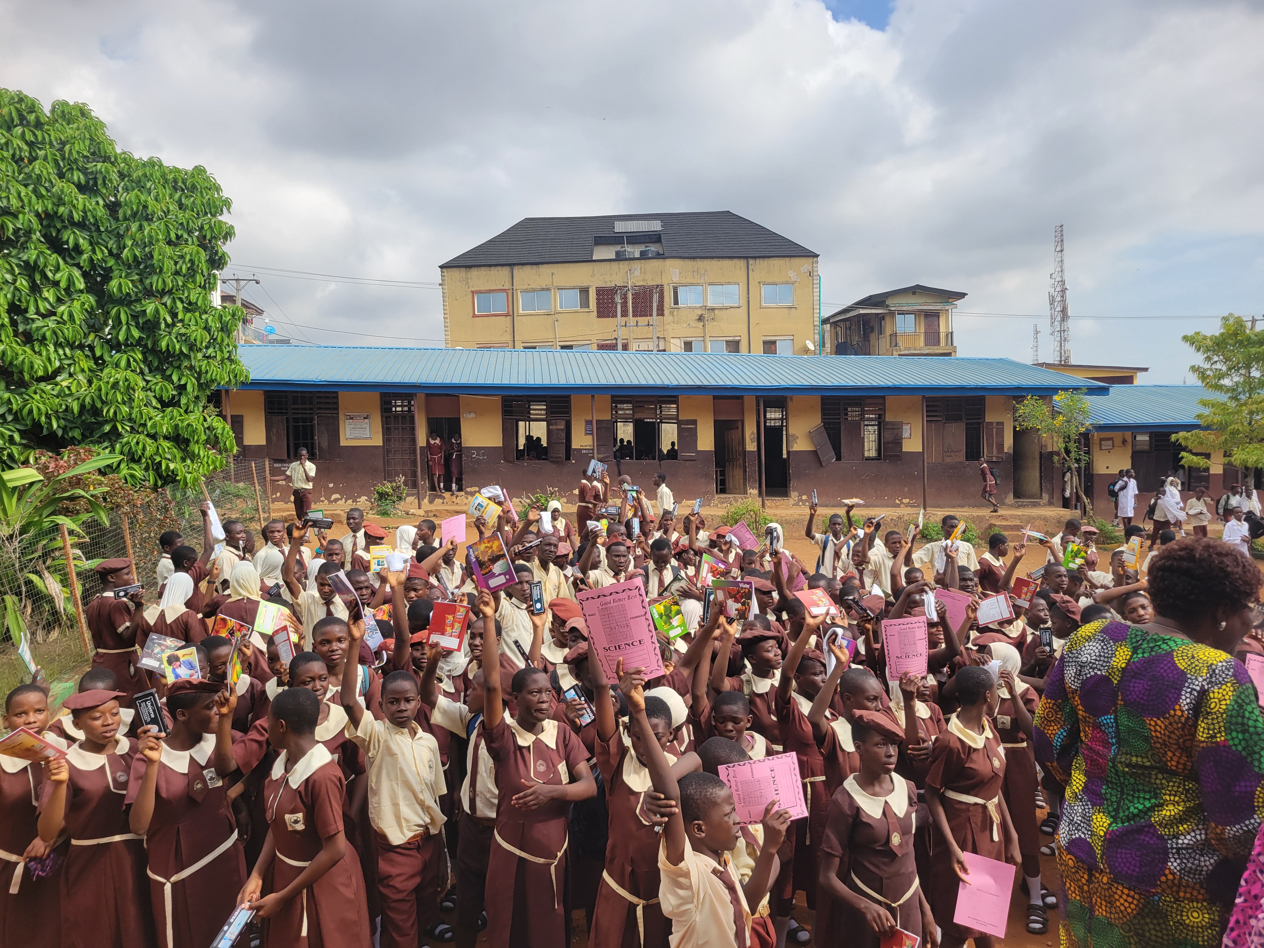 Hundreds of public school students holding donated learning materials, books and mathematical sets during Learn outreach.